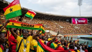 Ghana football supporters celebrating inside a packed World Cup stadium with Ghana flags and FIFA branding.