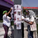 Activists place missing-person posters near a Mexico City stadium ahead of the 2026 FIFA World Cup.