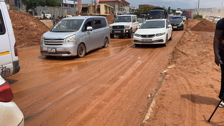Vehicles caught in heavy traffic on the Kasoa–Old Barrier road as motorists navigate a silt-covered section of the highway.
