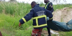 Ghana National Fire Service personnel recovering the body of an 11-year-old boy from a dugout pit at Adenta Aviation.