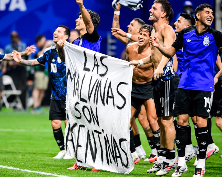 Argentina football players celebrate with a Las Malvinas son Argentinas banner after defeating England.