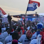 Supporters waving New Patriotic Party flags during a political gathering in Ghana.
