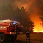 French firefighters responding to a large forest wildfire during a severe heatwave in southwest France.